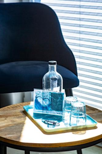 a bottle on a tray on a table with glasses at Hotel Bethanien in Langeoog