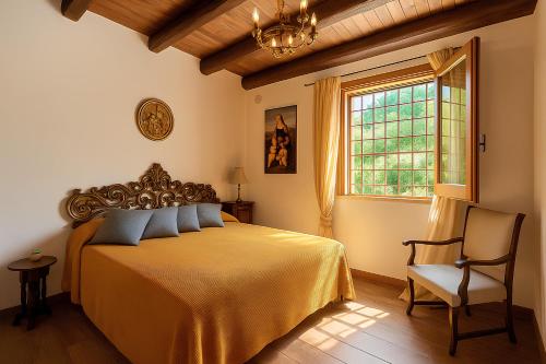 カステッルッツォにあるVilla Gheta presso Riserva Orientata Monte Cofanoのベッドルーム1室(ベッド1台、窓、椅子付)