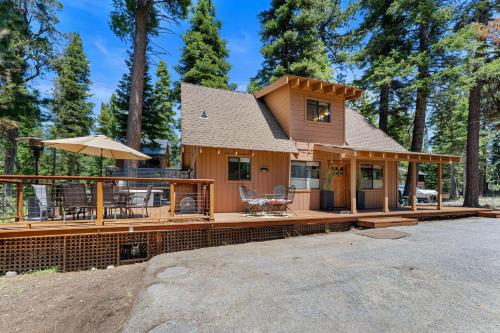 a house with a large deck in the woods at Lewis Ave Lodge in Tahoma
