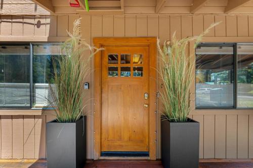 a house with two potted plants in front of a door at Lewis Ave Lodge in Tahoma