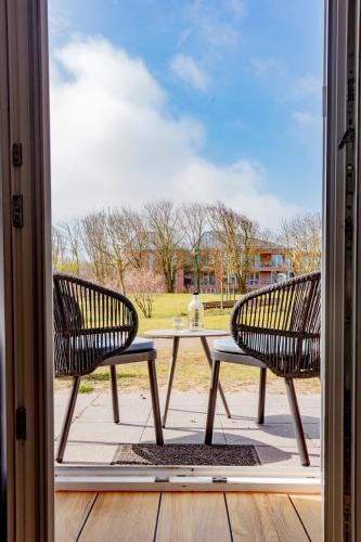 two benches sitting on a patio with a table at Hotel Bethanien in Langeoog