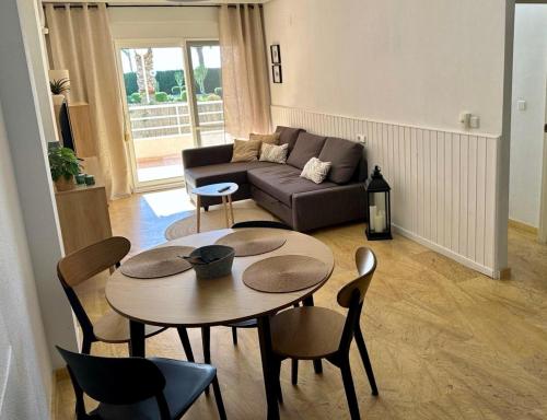 a living room with a table and chairs and a couch at Apartament z widokiem na morze Cabo Roig in Orihuela Costa