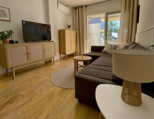 a living room with a couch and a tv at Apartament z widokiem na morze Cabo Roig in Orihuela Costa