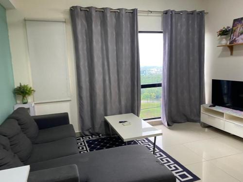 a living room with a couch and a large window at Hyve Soho suite in Cyberjaya