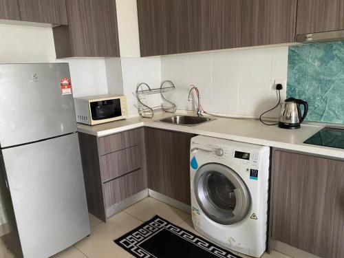 a kitchen with a washing machine and a sink at Hyve Soho suite in Cyberjaya