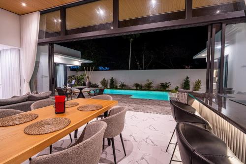 a dining room with a table and chairs and a swimming pool at Villa Leo - Fisherman's Village in Amphoe Koh Samui