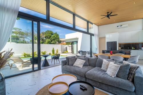 an open living room with a couch and tables at Villa Leo - Fisherman's Village in Amphoe Koh Samui