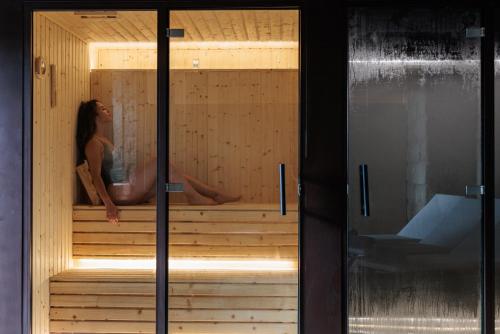 a woman is sitting in a sauna at MS Collection Arouca - Mosteiro de Arouca in Arouca