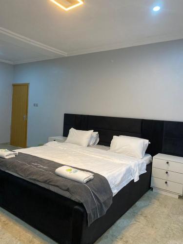 a large bed with a black headboard in a bedroom at Folulakes Regal Villas in Ibadan