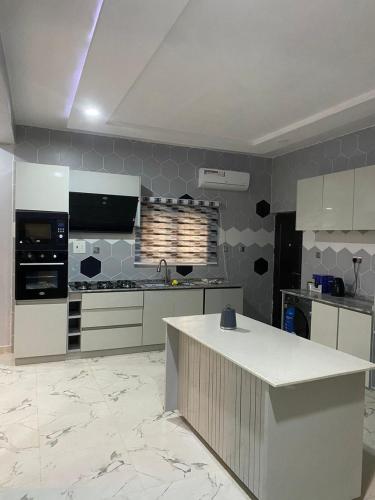 a kitchen with white cabinets and a counter in it at Folulakes Regal Villas in Ibadan