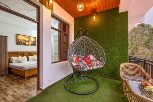 a room with a bird cage on a green wall at Snowfall View Home Kasauli Operated By Splendid Hotels in Kasauli