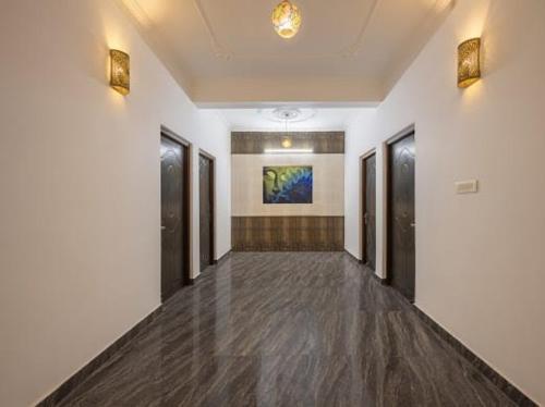 an empty hallway of a building with black doors at Snowfall View Home Kasauli Operated By Splendid Hotels in Kasauli