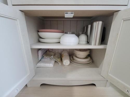 a cupboard filled with plates and bowls and dishes at ローズパーク弐番館103号室 in Funabashi
