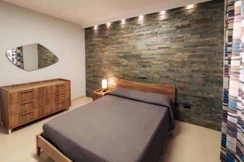 una camera da letto con un letto e un muro di mattoni di B&b Dante a Gravina in Puglia