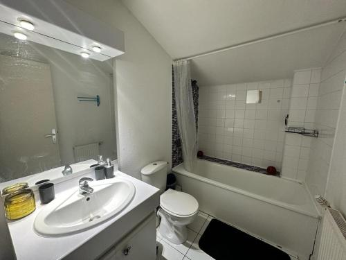 a bathroom with a sink and a toilet and a tub at Le Mérignac Loft - Proche Aéroport in Mérignac