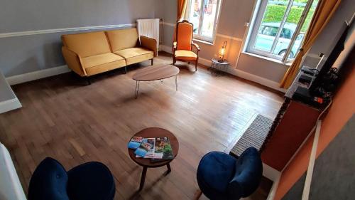 an overhead view of a living room with a couch and a table at La maison du voyageur toque in Charleville-Mézières