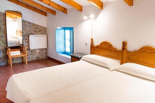 a bedroom with a large white bed and a mirror at Casa Pedroso in Noja