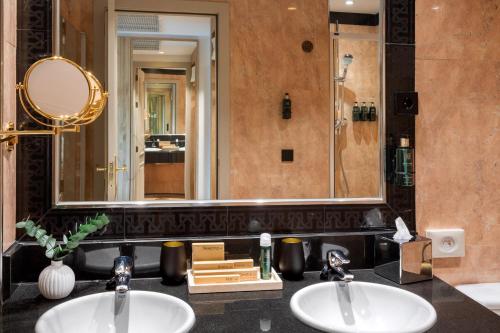 a bathroom with two sinks and a large mirror at Melia Barajas in Madrid