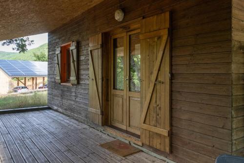 eine Holztür an der Seite eines Hauses in der Unterkunft Chalet Orange - Piscine Partagée in Darbres
