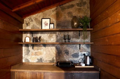 a kitchen with wooden walls and wooden shelves at Flora Handüzü Resort & Wellness Bungalow Hotel in Rize