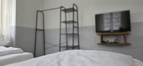 a bedroom with a bed and a television on a wall at My Pension 01 in Leinfelden-Echterdingen