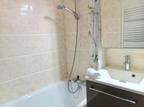 a bathroom with a shower and a tub and a sink at La Parenthèse - Appartement vue sur les montagnes in Morzine