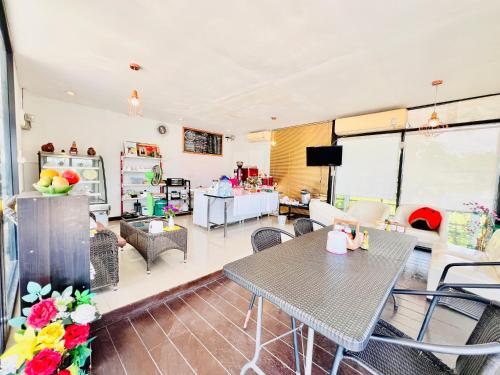 a living room with tables and chairs and a kitchen at Rungreang Hotel in Ban Phai
