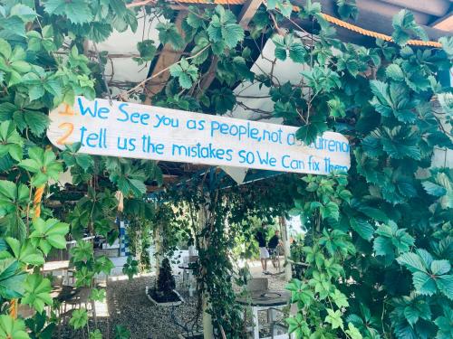 a sign hanging from a wall with plants at NoLux Camping Tent in Borsh