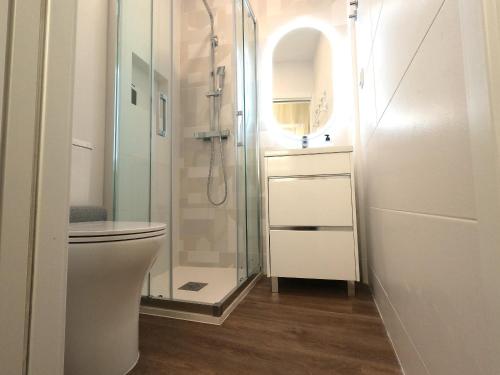 a bathroom with a toilet and a glass shower at Almada, Seixal T0 in Seixal