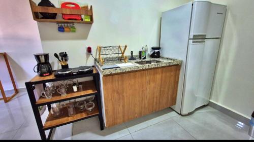 Una cocina con frigorífico de acero inoxidable y fregadero. en Apartamento no centro de Tatuí 2, en Tatuí