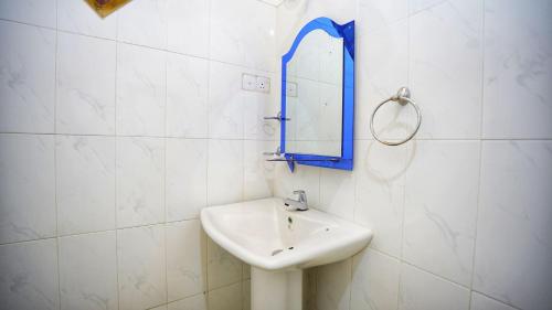a white bathroom with a sink and a mirror at Jungle Nature Villa in Sigiriya