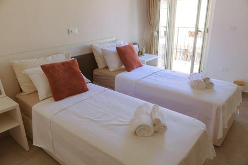 two beds in a hotel room with towels on them at Casa Vacanze - Le Dimore Del Borgo Antico in Campomarino