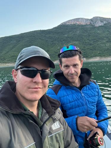 two men standing on a boat in the water at Kamp Bilećko Jezero in Trebinje