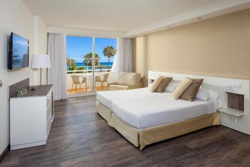 a bedroom with a bed and a view of the ocean at Sol Lanzarote - All Inclusive in Puerto del Carmen