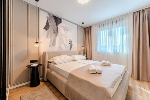 a bedroom with a bed with two towels on it at Villa Ballat with heated pool in Privlaka