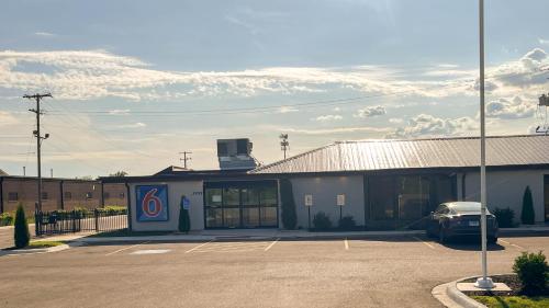 a building with a car parked in a parking lot at Studio 6 Rockford, IL – RFD Airport in Rockford
