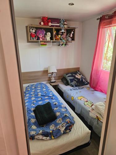 a bedroom with two beds and a window at Les sables du midi in Valras-Plage