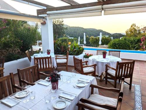 a patio with tables and chairs and a pool at Hotel Rural Can Maries in Puerto de San Miguel