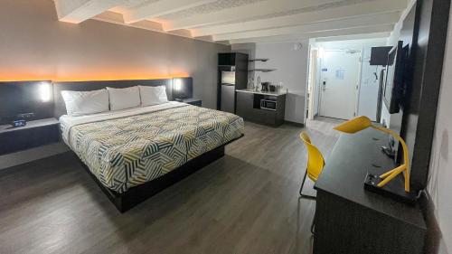 a hotel room with a bed and a desk at Studio 6 Rockford, IL – RFD Airport in Rockford
