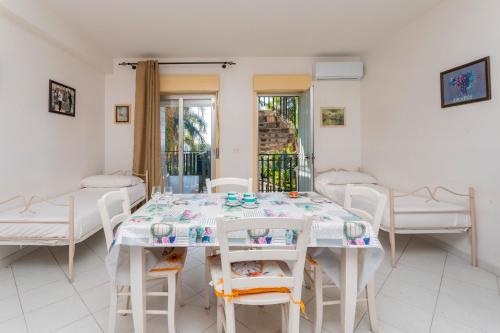 a white dining room with a table and chairs at I Ciottoli Dello Ionio in Mascali