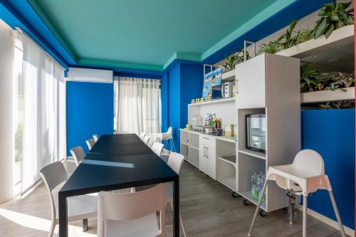 a dining room with blue walls and a black table and white chairs at Nautilus Family Hotel in Pesaro