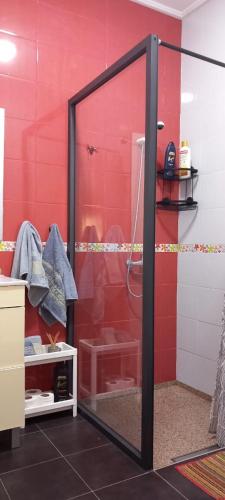 a shower with a glass door in a bathroom at Red Apartamento in Asilah