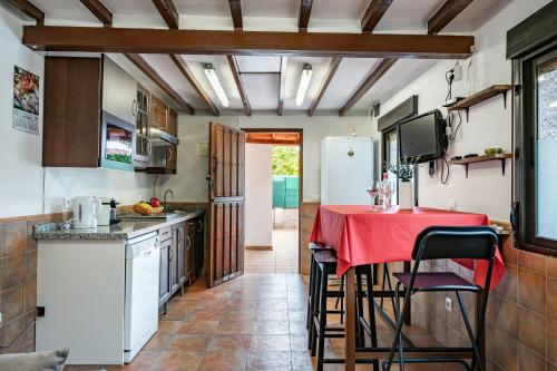 a kitchen with a table with a red table cloth at Ca Carmina in Colunga