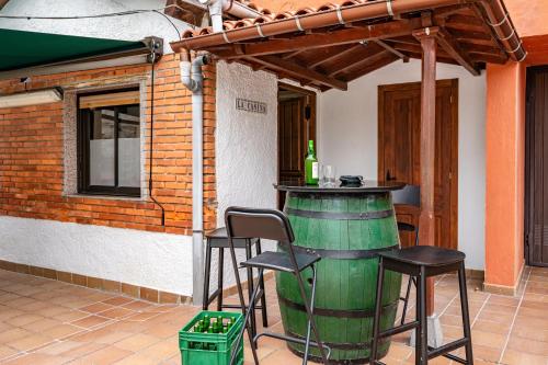 a patio with a bar with two chairs and a wine barrel at Ca Carmina in Colunga