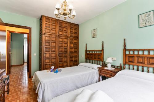 a bedroom with two beds and a chandelier at Ca Carmina in Colunga