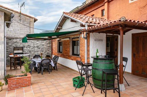 a patio with a table and chairs and a wine barrel at Ca Carmina in Colunga