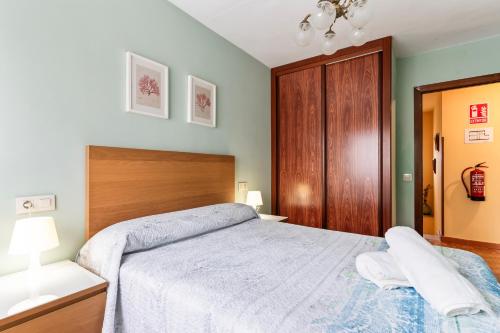 a bedroom with a large bed with a wooden headboard at Ca Carmina in Colunga