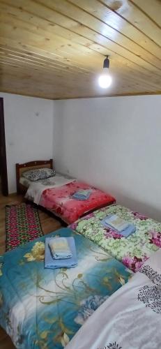 two twin beds in a room with a ceiling at Bujtina Sherifaj in Valbonë