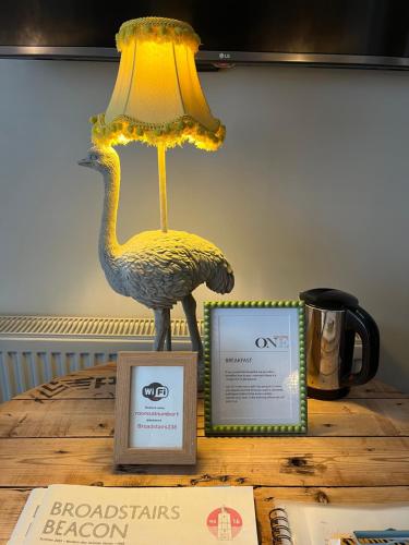 a lamp sitting on top of a table next to a box at Rooms at number one in Broadstairs
