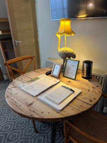 a table with a laptop and a lamp on it at Rooms at number one in Broadstairs